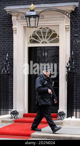 An armed police officer passes the front of 10 Downing Street, the official residence of Britain's Prime Minister Gordon Brown, in central London March 31, 2009.  The G20 Summit will be held in London on Thursday.  REUTERS/Toby Melville    (BRITAIN)