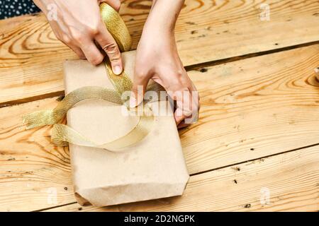 Close-up shot of woman hands packing christmas gift at home. Make Christmas gifts. DIY Christmas gifts to family Stock Photo