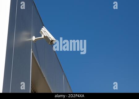 Closeup of a surveillance camera and clear sky. Stock Photo
