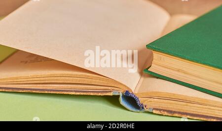The closed book lies on the open book. Close-up, macro Stock Photo