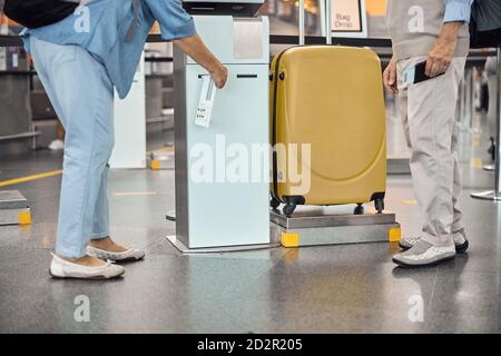 Passenger using a self-service kiosk for receiving a bag tag Stock Photo