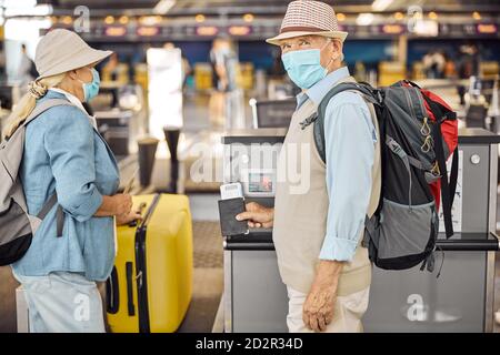 Female passenger putting a suitcase on the conveyor belt Stock Photo