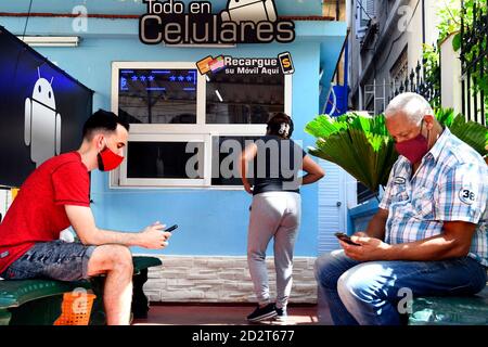 Havana, Cuba. 5th Oct, 2020. People wearing face masks wait in front of a cell phone repair shop in Havana, Cuba, Oct. 5, 2020. Credit: Joaquin Hernandez/Xinhua/Alamy Live News Stock Photo