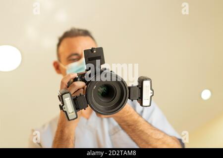 Low angle view of dentist doctor holding a professional photo camera with ring flash Stock Photo