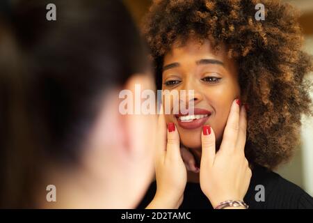 Close up view of anonymous Woman dentist checking teeth of African American lady in dental clinic Stock Photo