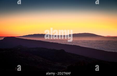 Picturesque scenery of peaceful sea and silhouette of mountains range under vivid sunset sky in Tenerife Stock Photo