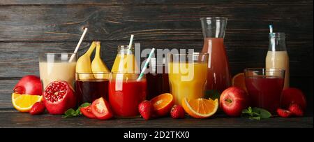 Glasses and jars with different juices on wooden background Stock Photo