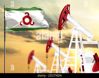 Oil rigs against the backdrop of the colorful sky and a flagpole with the flag of Ingushetia. The concept of oil production, minerals, development of Stock Photo