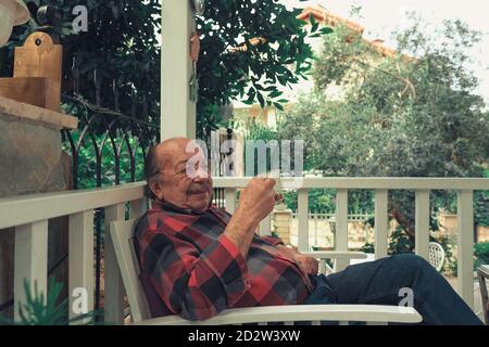 Portrait of senior man drinking coffee. Elderly man sitting with cup of coffee in his hand. Stock Photo