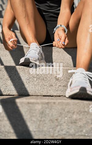 unrecognizable female tossing glass of fresh water with ice and lemon on light blue background showing concept of diet Stock Photo