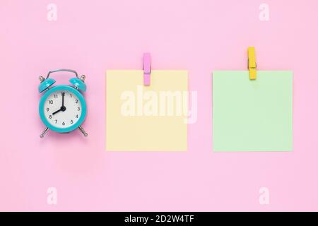 Two blank stickers on notice board, planning concept, deadline. Place for text, copy space. Colorful note paper with clothespins on a pink background. Stock Photo