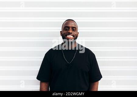 Happy black man posing and smiling over white background and looking at camera Stock Photo