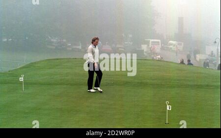 Bernard Langer in the fog on the practice putting green whilst he waits patiently for the fog to lift on the first day) of the World Matchplay Championships at Wentworth. Stock Photo