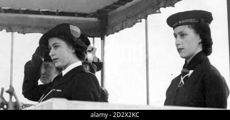 Princess Elizabeth (later Queen Elizabeth II), in her uniform of Sea Ranger, and Princess Margaret (right), at a drumhead service and march past by Girl Guides in London's Hyde Park. Stock Photo