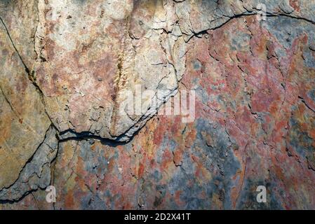Scaly surface of a slate rock plate with reddish coloration due to the presence of ferric oxides Stock Photo