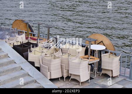 Summer cafe is closed due to bad weather, folded furniture-tables, chairs, umbrellas Stock Photo