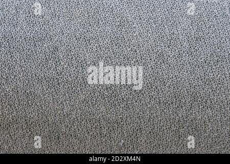 Texture of a gray fabric made of connected threads, background. Grey wool yarn curled into a uniform fabric. Stock Photo