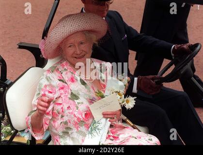 The Queen Mother waves to the crowds of well-wishers who had gathered outside her London home today (Mon) as she is driven away in her 'Queen Mum Mobile' after the Royal Regiment of Wales' traditional Army tribute to her on her 97th Birthday. See PA story ROYAL Mother. Photo Stefan Rousseau/PA Stock Photo