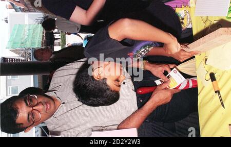 Demonstrates a left handed potato peeler in london hi-res stock