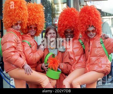 Adrian Altman, 29, from Derbyshire (centre) surrounded by some feathered friends, displays his new purchase from the newly opened, re-designed Swatch Store on London's Oxford Street today (Saturday).  Mr Altman travelled down to the capital last night to ensure he was first in the queue for his limited edition, orange feathered Swatch Watch.  Only  500 of the unusual watches are available, one per person, priced  55.  Photo by Sean Dempsey/PA Stock Photo