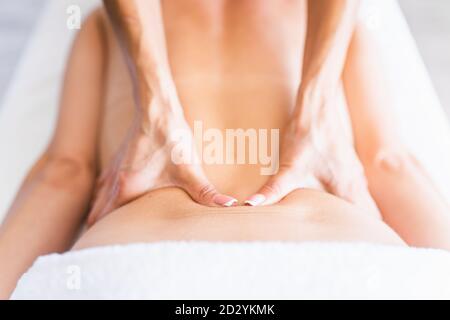 Woman receive back massage in light room. Stock Photo