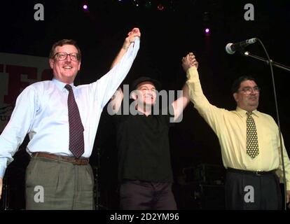 U2 rock star is flanked by UUP leader David Trimble (left) and SDLP leader John Hume on stage during a special concert in Belfast to promote the 'Yes' vote in the peace referendum in Northern Ireland. * 17/09/2001: John Hume announced that he was to stand down as the leader of the SDLP. Stock Photo