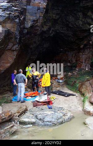 Coastguards and RNLI Crew recover the smashed Lifeboat from the cave at Bosinney Cornwall this afternoon. Hotelier Nick Leeds and his 11-year-old son James, with two lifeboatmen who tried to rescue them were plucked to safety last night (Sunday) from the cave at Benoath Beach, near Bossiney, north Cornwall, by the RAF Sea King from RAF Chivenor, north Devon. Photo by Nigel Bennetts/PA. See PA story SEA Cave. Stock Photo