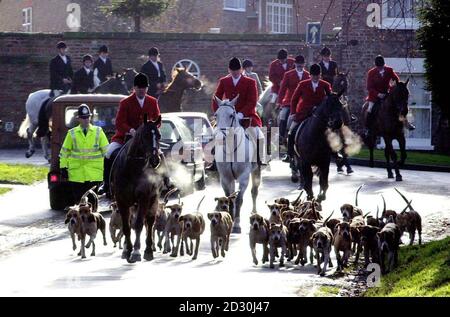 The York and Ainsty Hunt leave Easingwold for the traditional boxing Day Hunt Meet, with a Policeman walking alongside to deter any disruption from the Anti-hunting lobby who gathered to protest against the hunt. Stock Photo
