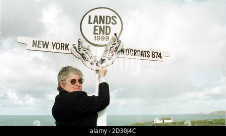 Cilla George 'End to End' co-ordinator with Ian Botham's trainers at the Lands End sign. A pair of battered trainers belonging to cricketer Ian Botham are the latest exhibit in the museum which chronicles 120 years  of journeys between John O Groats and Land s End.    *The 43-year-old former England all-rounder donated the shoes after finishing his 871-mile charity trek to Britain s most westerly point in 34 days in November. Many of the more notable journeys are remembered in the  350,000 Miles of Memories exhibit at the Land s End complex, set up specifically to chronicle some of the heroic  Stock Photo