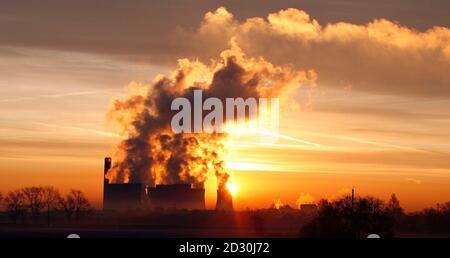The sun rises behind Fiddlers Ferry coal fired power station near Liverpool, northern England, December 15, 2008.     REUTERS/Phil Noble    (BRITAIN)