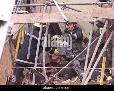 Firefighters search through the rubble of a collapsed building in ...