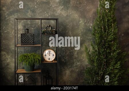 New Year grunge texture. Dark loft, concrete wall, Christmas tree in a garland with lights, modern, stylish rack, alarm clock, Copy space, banner, Stock Photo