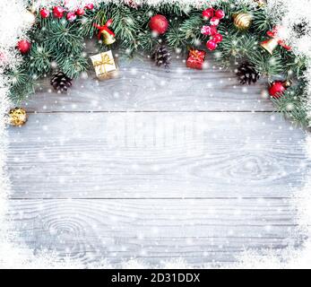 Christmas fir tree branches with toys on old wooden table with bokeh light. Beautiful Christmas background. Stock Photo