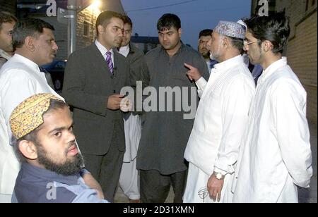 Shahid Malik, (3rd left top) back on the streets of Burnley, Tuesday June 26 2001 talking to Asian community leaders near to where he was injured last night. Malik claimed he was knocked to the ground and injured by police during Monday's night of sporadic violence. Mr Malik, 33, a member of Labour's National Executive Committee and the Commission for Racial Equality, needed hospital treatment after the incident. He was arrested but later released to be interviewed at a later date and claimed he was beaten unconscious with a riot shield as he appealed for calm. Twenty-one people, both white an Stock Photo