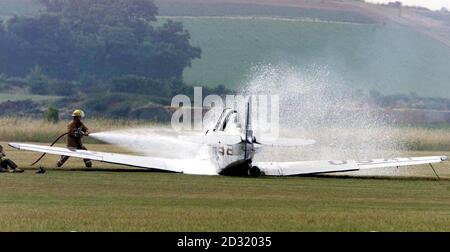 Fire crews attend to the crew and extinguish the fire after a two seater Harvard T6 plane Crashed on take off at RAF Duxford, Cambridgeshire, prior to an air show. It is not thought that anyone was injured in the accident.   *  at the Imperial War Museum's aviation headquarters at Duxford.  Stock Photo