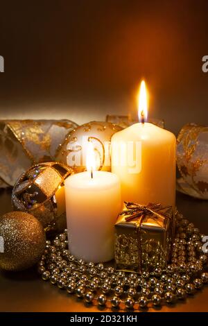 Christmas decoration with burning candles on a dark background. Christmas ornaments over dark golden background with lights. Stock Photo