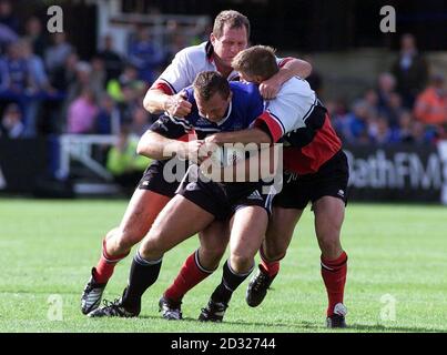 Bath's Nathan Thomas is tackled by Richard Hill and Tim Horan of Saracens during the Zurich Premiership game between Bath and Saracens at the Recreation Ground, Bath. Stock Photo