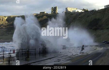 A runner beats a hasty retreat as enormous waves batter the North Bay at Scarborough, north Yorkshire, as severe gales sweep northern England.   * Thousands of homes elsewhere were without electricity after gale force winds and wintry showers battered parts of Britain and Northern Ireland. Winds of up to 85mph brought power lines and trees down in Scotland while snow and sleet made driving conditions difficult. Stock Photo