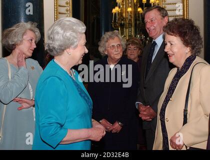 Britain's Queen Elizabeth II, and Baroness Hayman meet, L to R Joyce Taft, Michael Gooley and Alice McNaughton at a Cancer Research UK reception at Buckingham Palace. Stock Photo