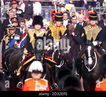 Prince Harry lowers his head as he and other members of the Royal Family follow the coffin of Queen Elizabeth the Queen Mother from the Chapel Royal to Westminster Hall.  Her coffin will lie-in-State there until the funeral. Stock Photo