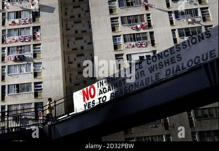 A man looks at a sign asking voters to vote no to concessions and yes to a dialogue in front of a block of flats covered in flags and washing in the centre of Gibraltar, * ahead of the referendum over the principle that Britain and Spain should share sovereignty over the colony. Spain has a claim over Gibraltar dating back to the 1713 Treaty of Utrecht, and in recent years London and Madrid have become close to agreeing a deal on its future, but it is expected that the overwhelming majority of the 27,000 residents will vote to block any attempt by the British government to give Spain parti Stock Photo
