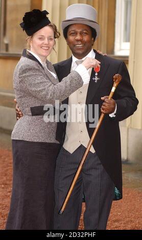 DJ Norman Jay and his wife Marie from west London  pose with the MBE that Norman was awarded at Investitures at Buckingham Palace at Buckingham Palace. Jay was among some 150 people who received awards from the Queen at Buckingham Palace. Stock Photo