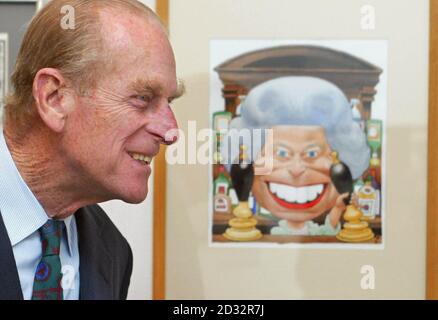 The Duke of Edinburgh looks at a cartoon of Britain's Queen Elizabeth II standing behind the bar in the Old Vic pub from TV show Eastenders drawn by Trogg for the Golden Jubille.  * The Duke was on a visit to the Cartoon Art Trust's Kings and Queens exhibition at the Mall Galleries, London, of which he is a patron. Stock Photo