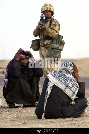 Soldiers from the Household Cavalry stop suspected Iraqi soldiers at a checkpoint in southern Iraq. Stock Photo