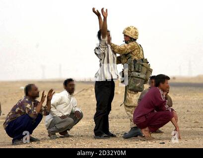 Soldiers from the Household Cavalry stop suspected Iraqi soldiers at a checkpoint in southern Iraq. Stock Photo