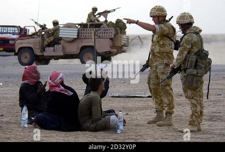 Soldiers from the Household Cavalry stop suspected Iraqi soldiers at a checkpoint in southern Iraq. Stock Photo