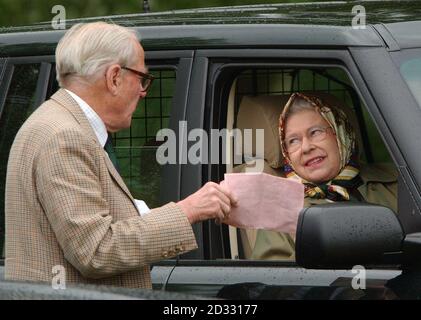 Britain's Queen Elizabeth II chats with an official at the Royal Windsor Horse Show in Berkshire, where she was watching her husband Prince Philip competing in the International Driving Grand Prix. . Stock Photo