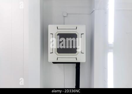 Four-way air conditioner mounted on the ceiling of the room, used for home or office. Stock Photo