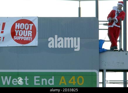A man dressed as Santa Claus, claiming to represent the group Fathers For Justice, stands on top of a gantry over the main A40 road in west London.  The man, who has not been named, is a lorry driver from north London who is understood to have had custody problems with his two children. Stock Photo