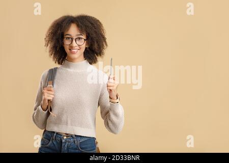 Got an idea, knowledge and education concept. Cute african american woman hipster with glasses and backpack raises pencil up Stock Photo